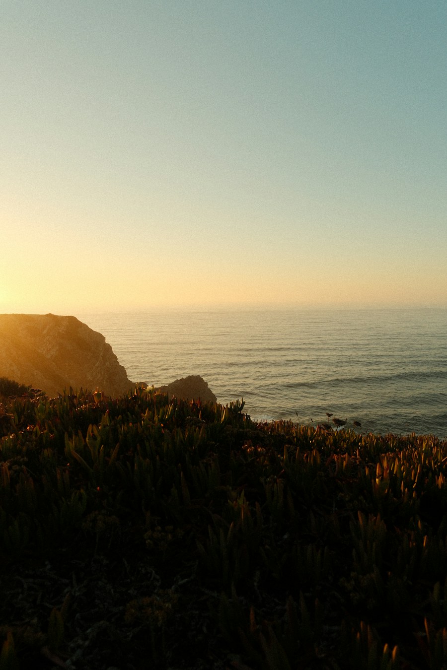 Warm sunset light over the ocean and coastal cliffs at Aljezur, Portugal